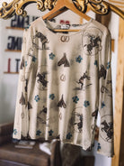 Thunderbird pendant chain necklace displayed on wooden slab with serape fabric underneath - The Wild J