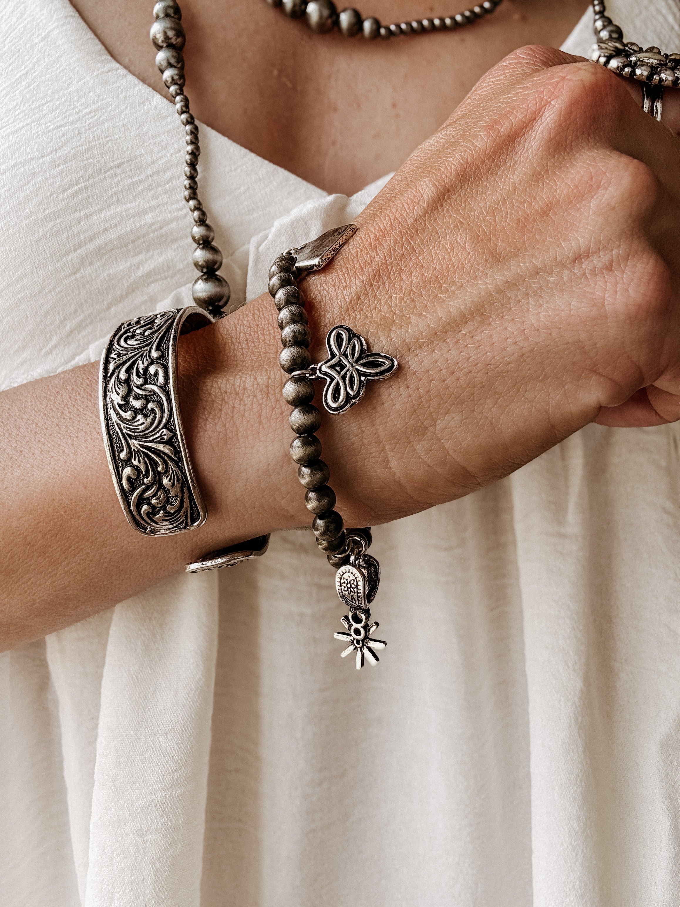 Thunderbird pendant chain necklace displayed on wooden slab with serape fabric underneath - The Wild J