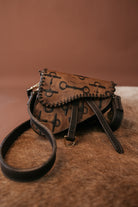 Thunderbird pendant chain necklace displayed on wooden slab with serape fabric underneath - The Wild J