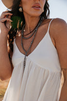 Thunderbird pendant chain necklace displayed on wooden slab with serape fabric underneath - The Wild J