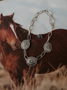 Silver western concho necklace and earrings set on a horse-themed background, boho jewelry