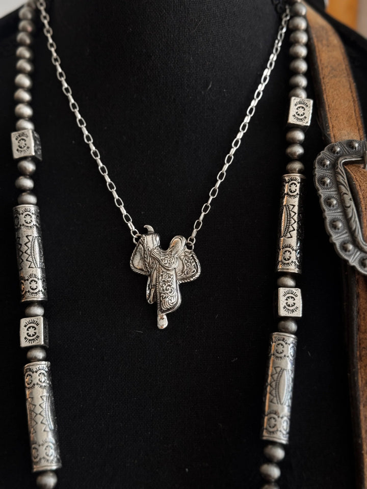 Silver necklace with a horse stirrup pendant on a black background
