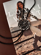 Thunderbird pendant chain necklace displayed on wooden slab with serape fabric underneath - The Wild J