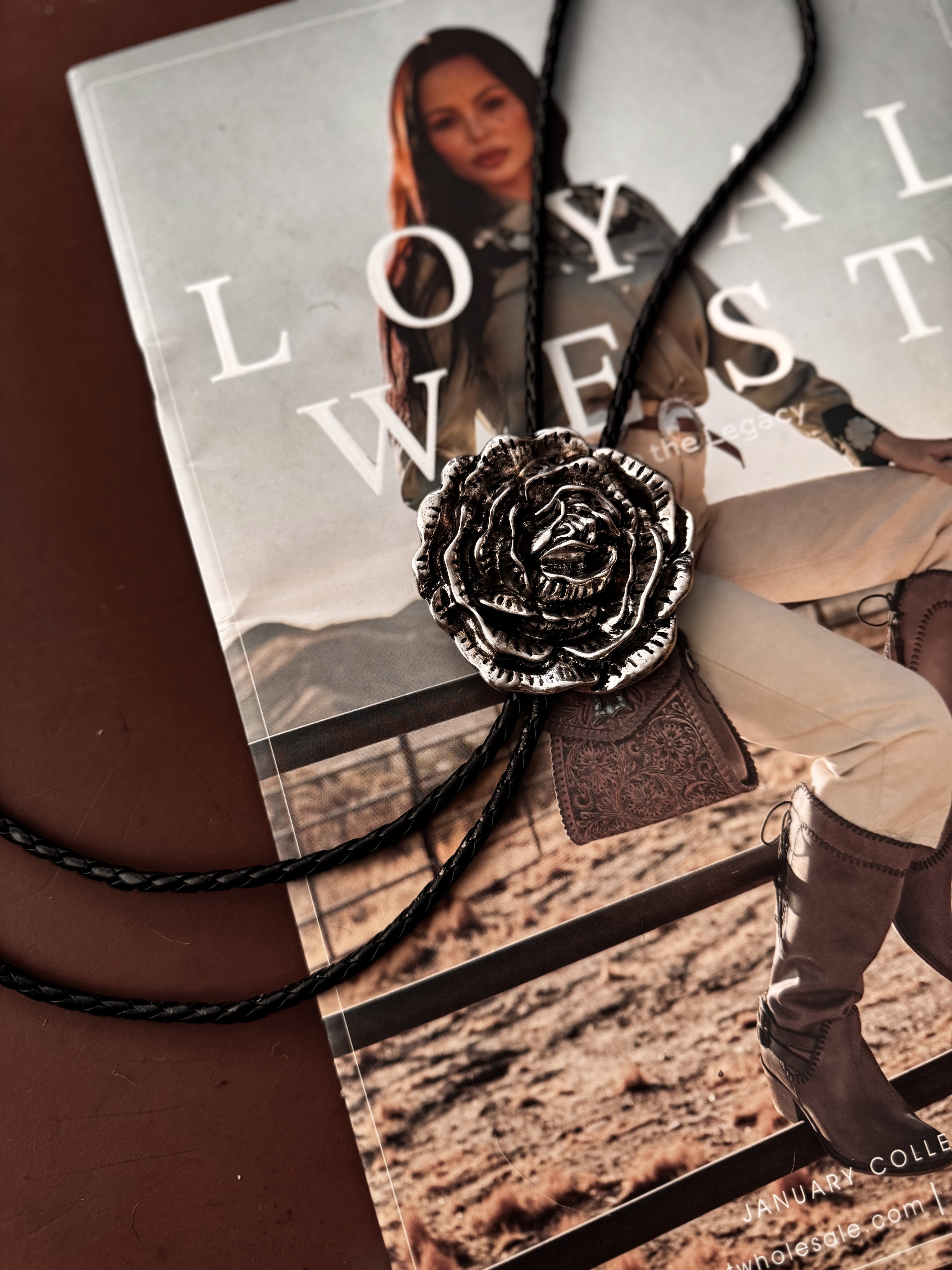 Thunderbird pendant chain necklace displayed on wooden slab with serape fabric underneath - The Wild J