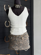White ribbed tank top and zebra print skirt on a mannequin against a dark background