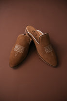 Thunderbird pendant chain necklace displayed on wooden slab with serape fabric underneath - The Wild J