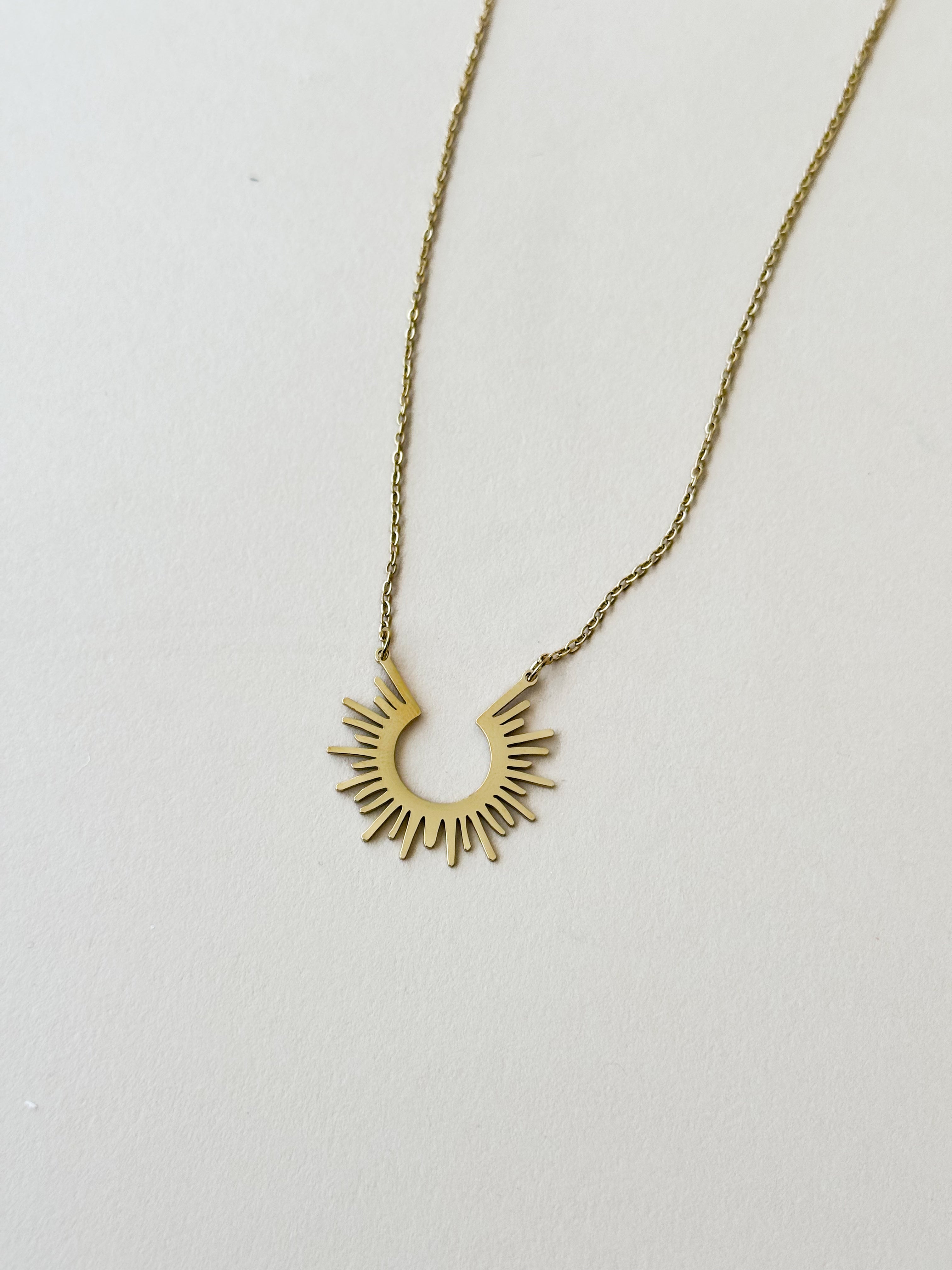 Thunderbird pendant chain necklace displayed on wooden slab with serape fabric underneath - The Wild J