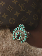 Turquoise western boho bracelet on cowhide with designer bag background