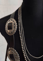 Thunderbird pendant chain necklace displayed on wooden slab with serape fabric underneath - The Wild J