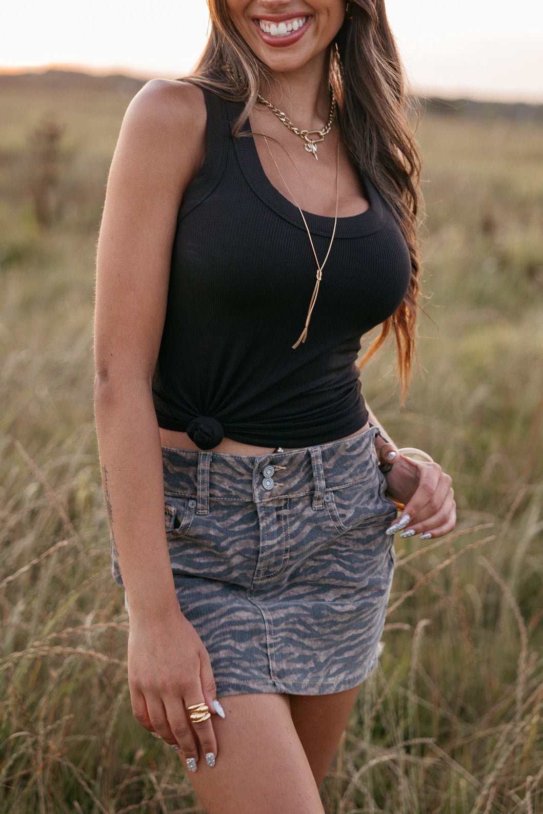 Woman wearing a cowboy hat and black top in a field