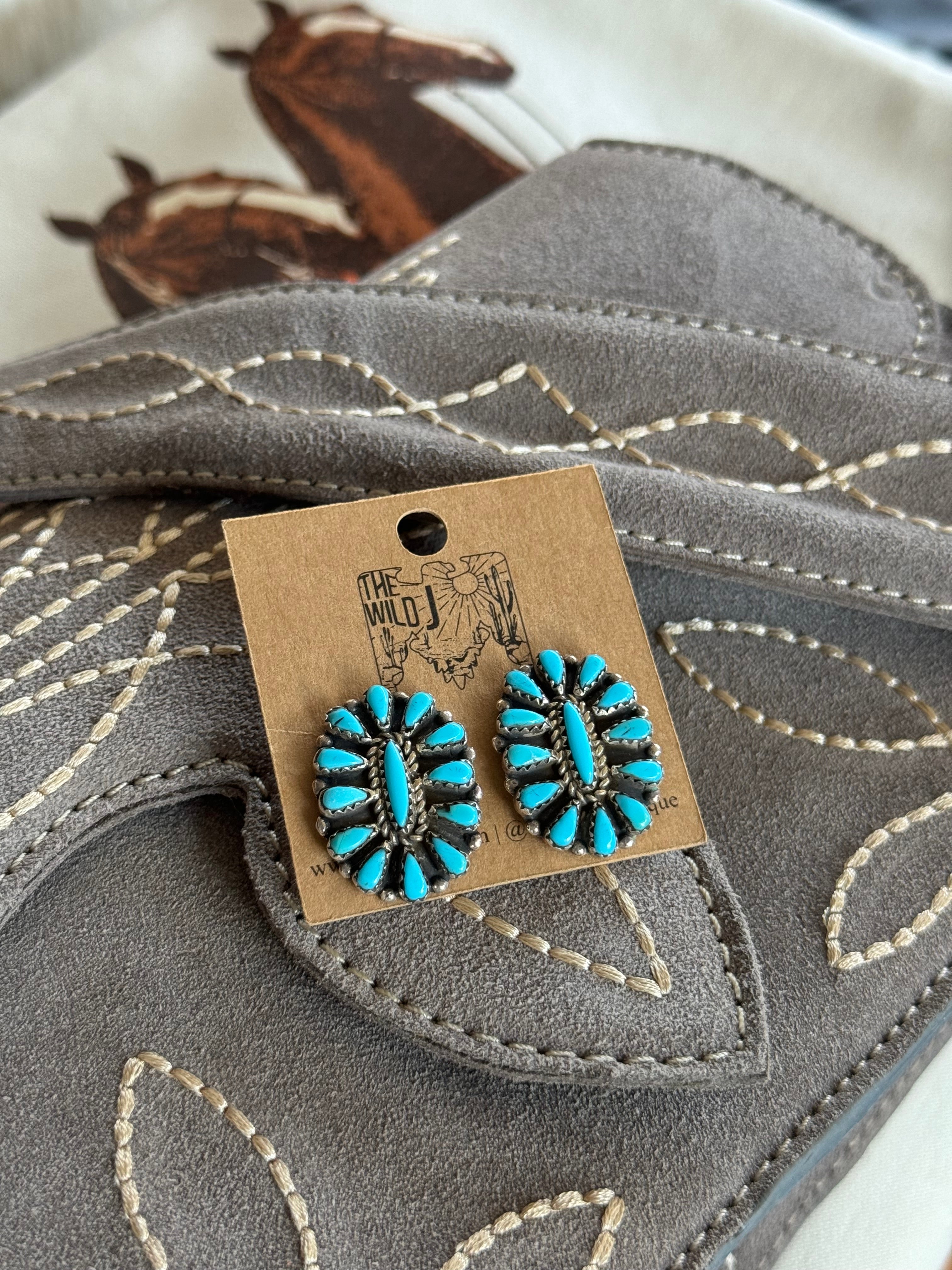 Turquoise western boho stud earrings on suede embroidered purse, horse print background