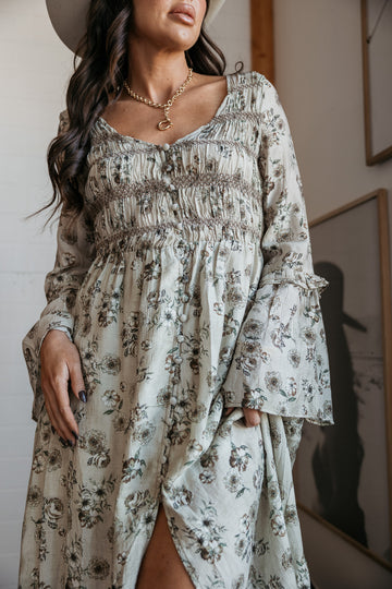 western boho dress in white with sage floral print with a slit and beige knee-high cowgirl boots close up