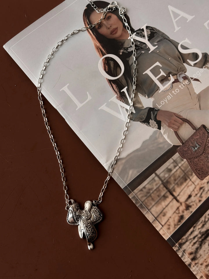 Silver necklace with a pendant on a magazine background