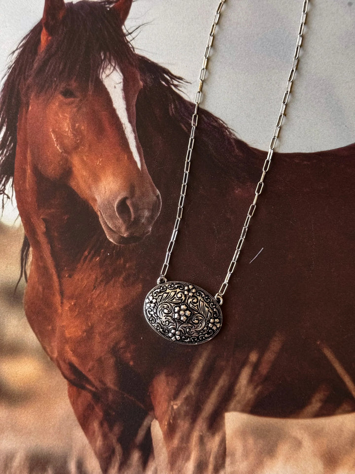 Horse with a detailed necklace pendant in a natural setting