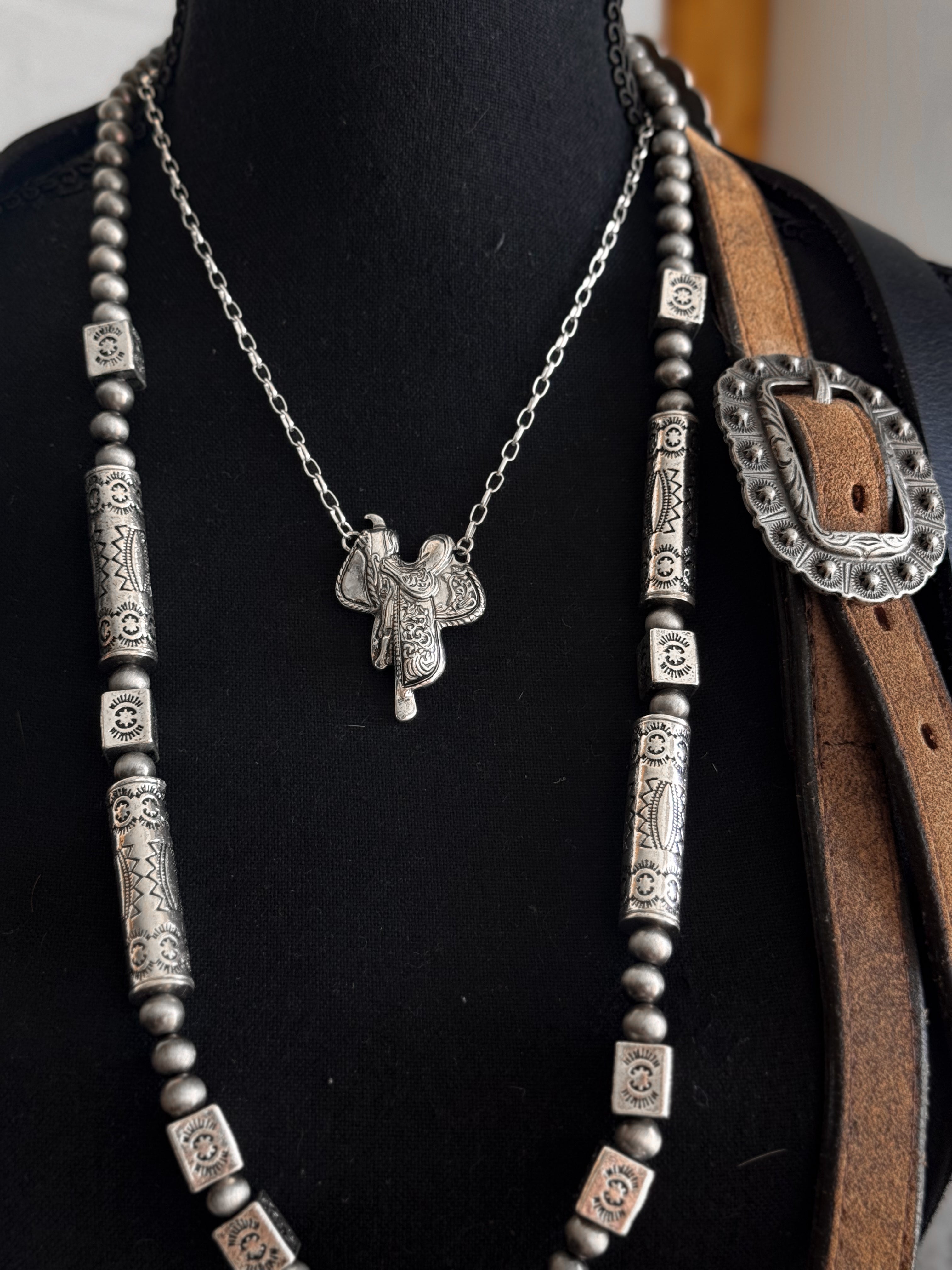 Thunderbird pendant chain necklace displayed on wooden slab with serape fabric underneath - The Wild J