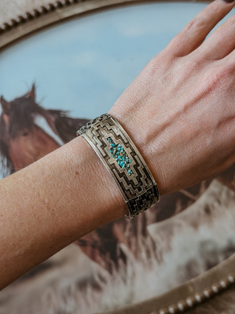 Thunderbird pendant chain necklace displayed on wooden slab with serape fabric underneath - The Wild J