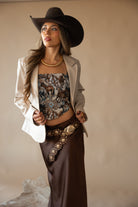 Thunderbird pendant chain necklace displayed on wooden slab with serape fabric underneath - The Wild J