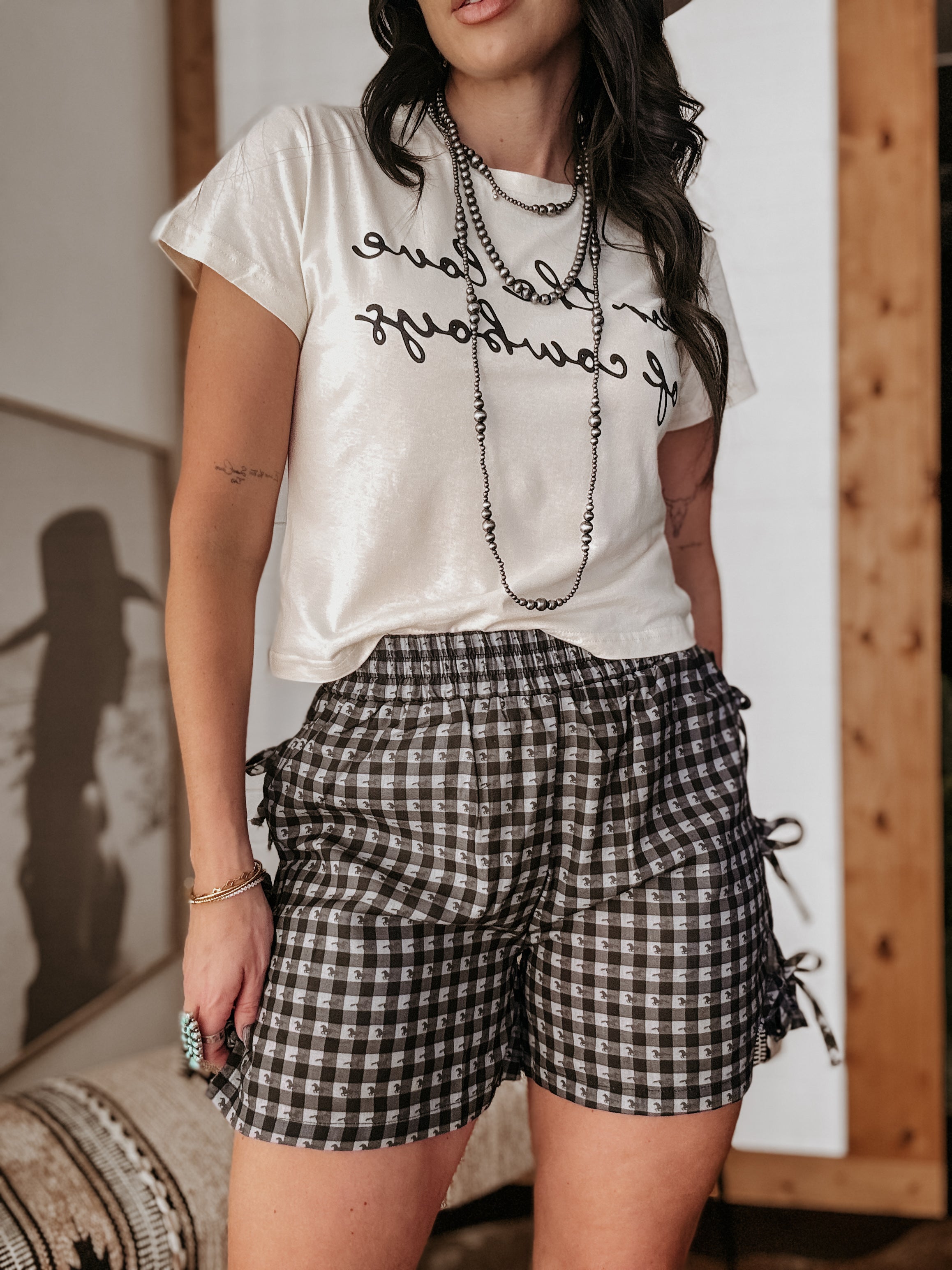 Thunderbird pendant chain necklace displayed on wooden slab with serape fabric underneath - The Wild J