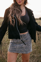 Woman in a cowboy hat and black jacket standing in a field