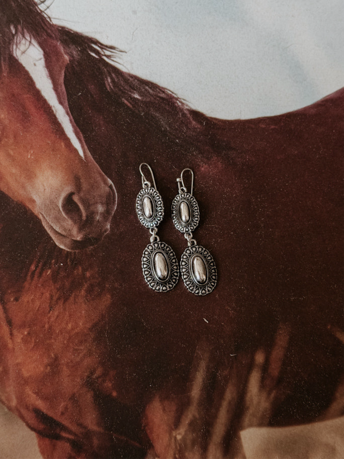 Thunderbird pendant chain necklace displayed on wooden slab with serape fabric underneath - The Wild J