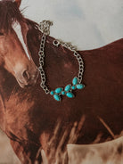 Thunderbird pendant chain necklace displayed on wooden slab with serape fabric underneath - The Wild J