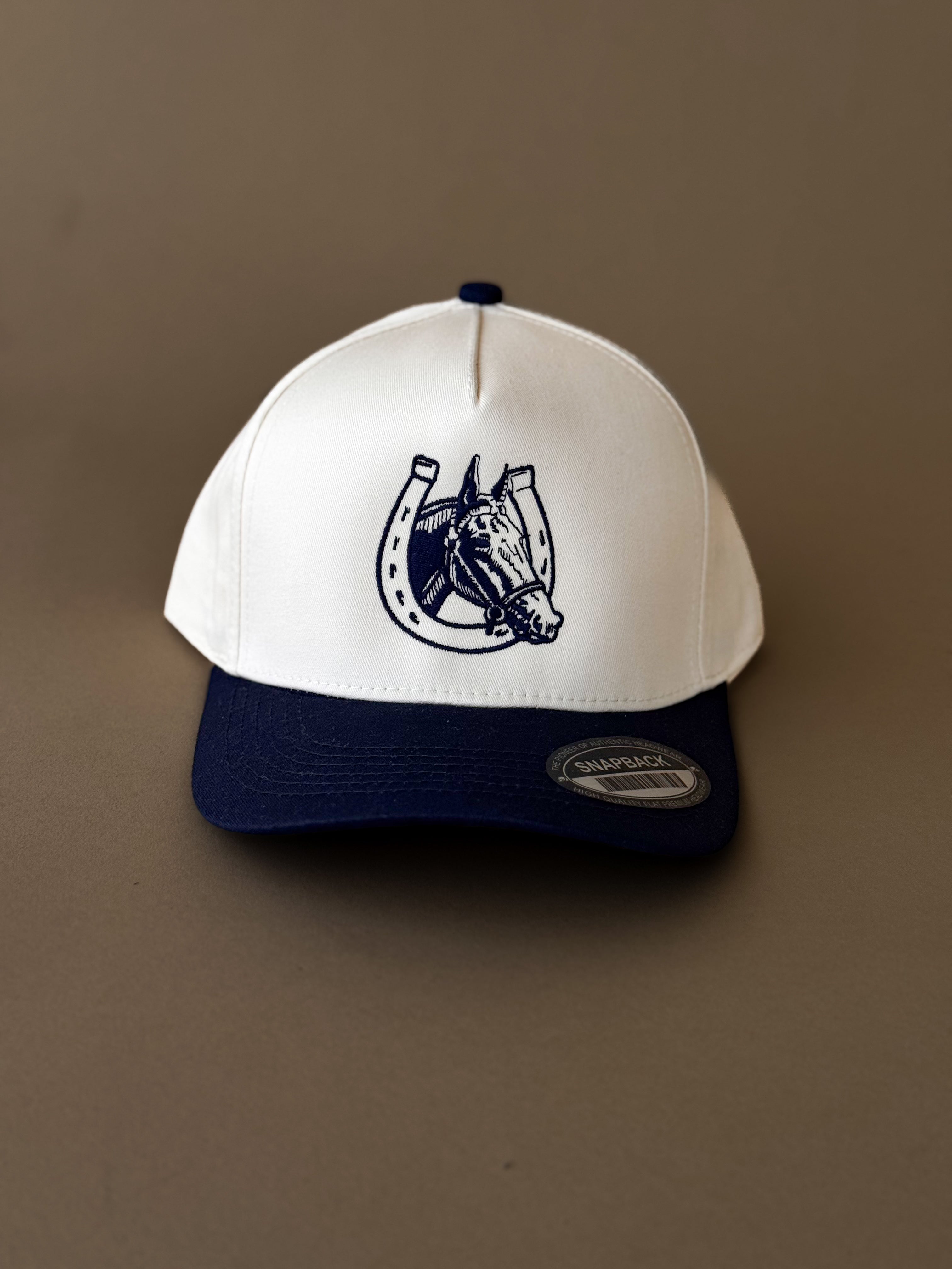 White and navy western snapback hat with embroidered horse and horseshoe design