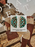 Turquoise sterling silver earrings, handcrafted, displayed on western fashion magazine with cowgirl boots.