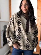 Woman wearing a patterned fleece jacket indoors