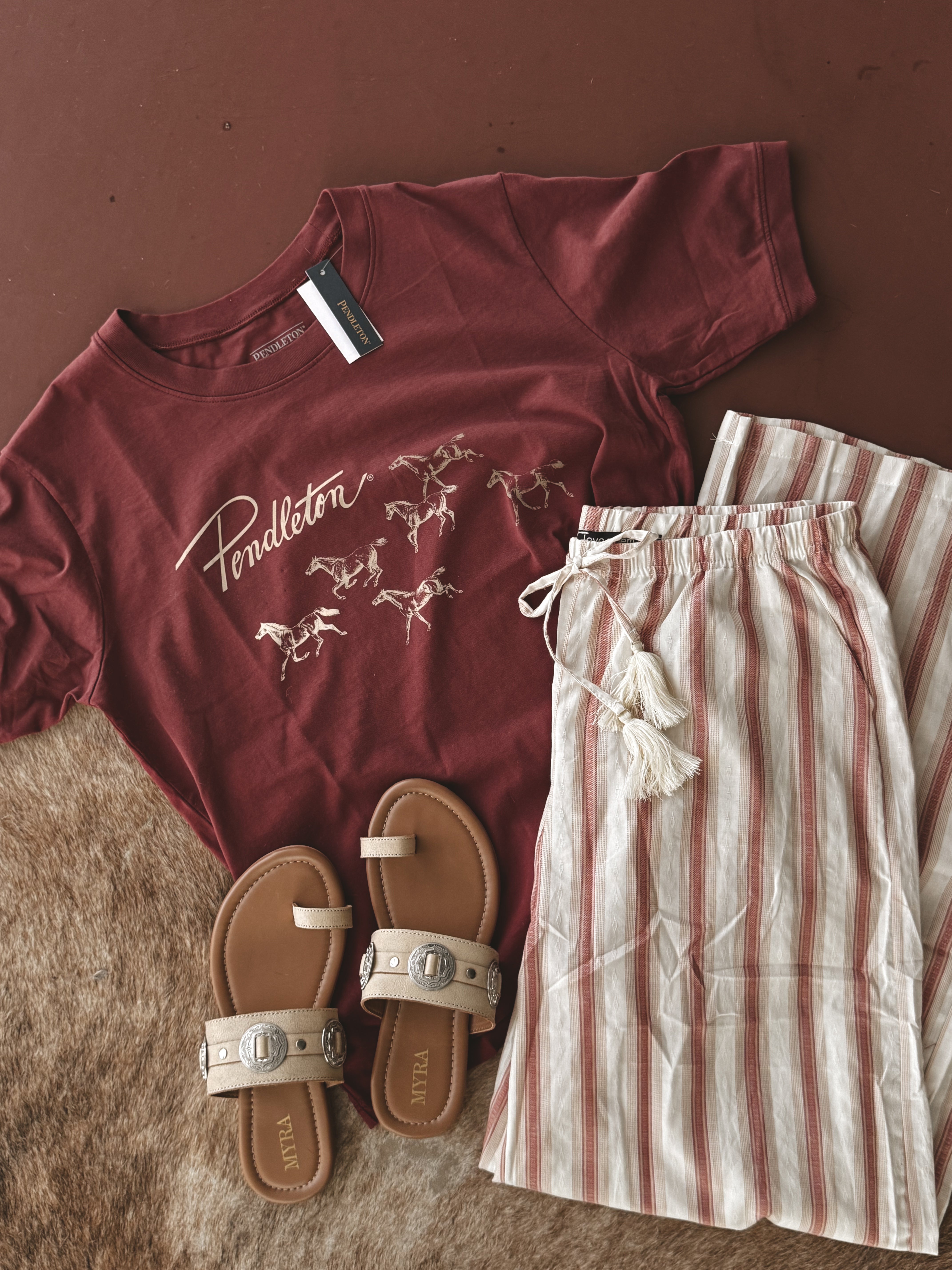 Thunderbird pendant chain necklace displayed on wooden slab with serape fabric underneath - The Wild J