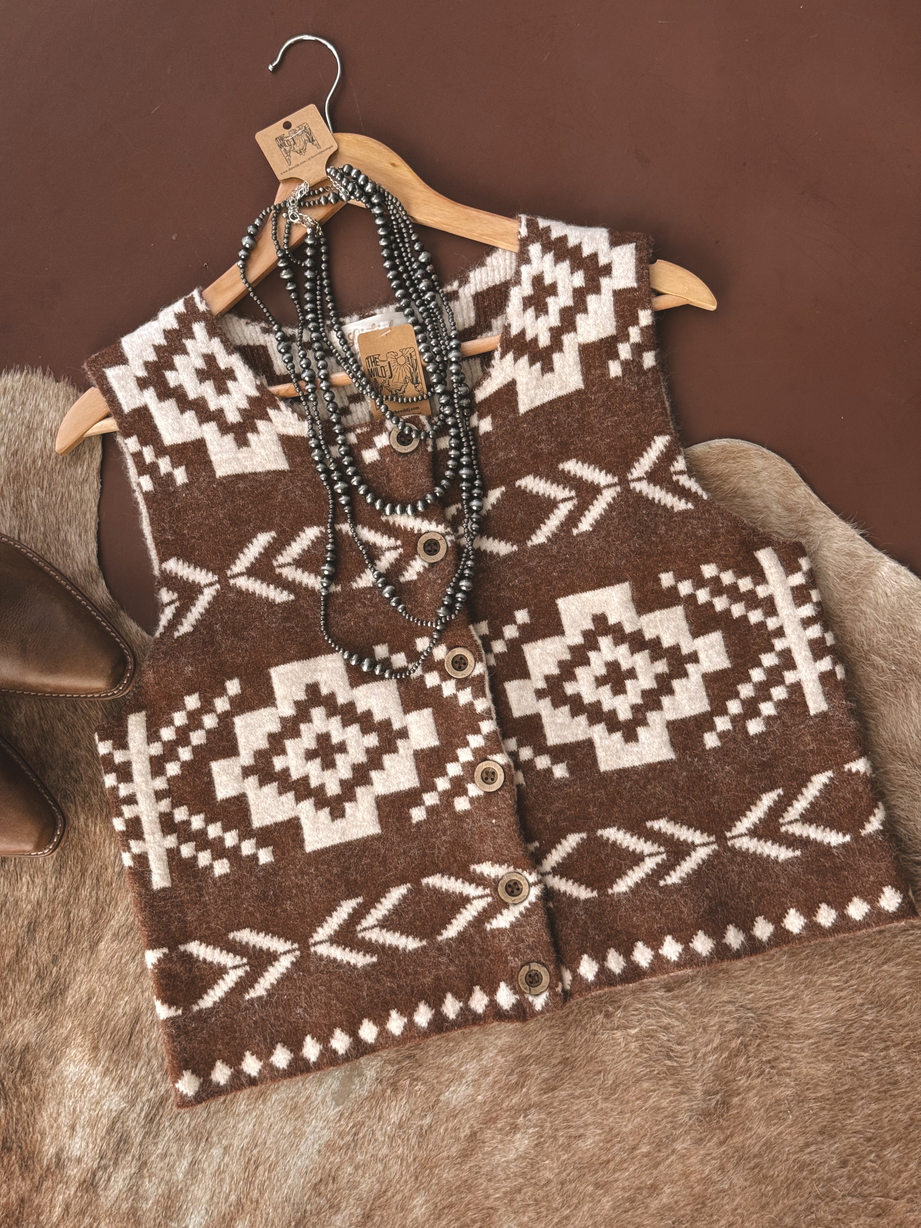 Western boho brown Aztec knit vest with buttons and layered turquoise necklaces on fur