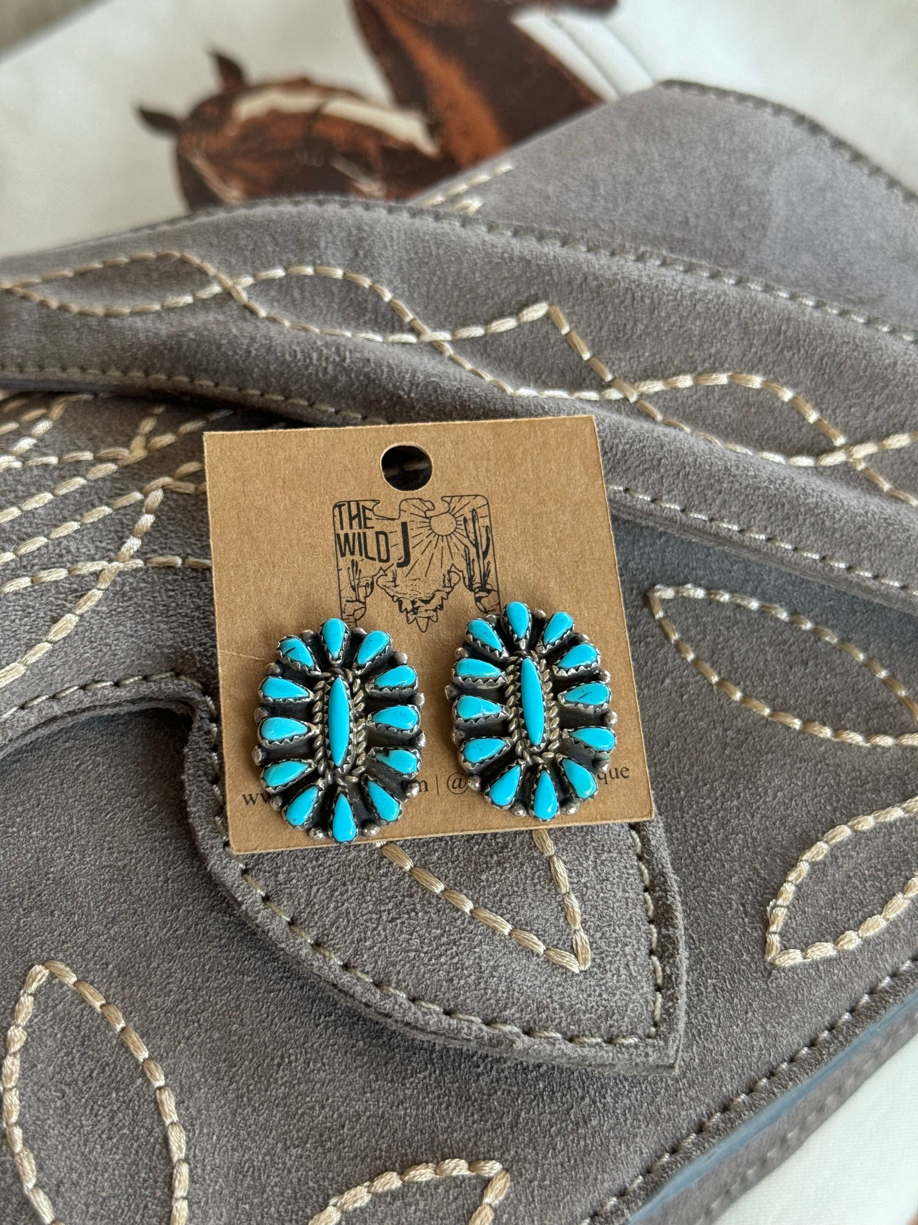 Turquoise western boho earrings with silver setting on stitched gray suede background