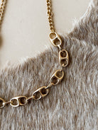 Thunderbird pendant chain necklace displayed on wooden slab with serape fabric underneath - The Wild J