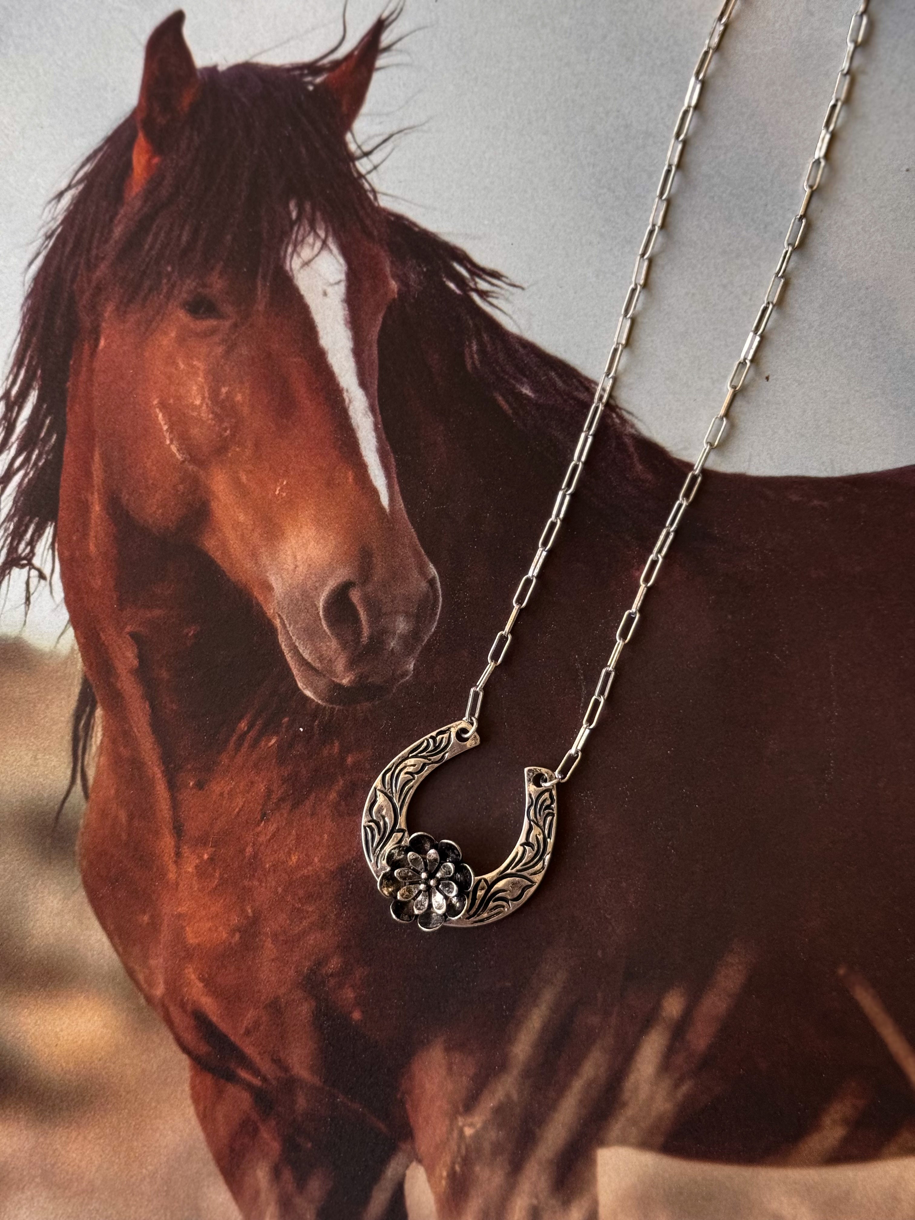 Thunderbird pendant chain necklace displayed on wooden slab with serape fabric underneath - The Wild J