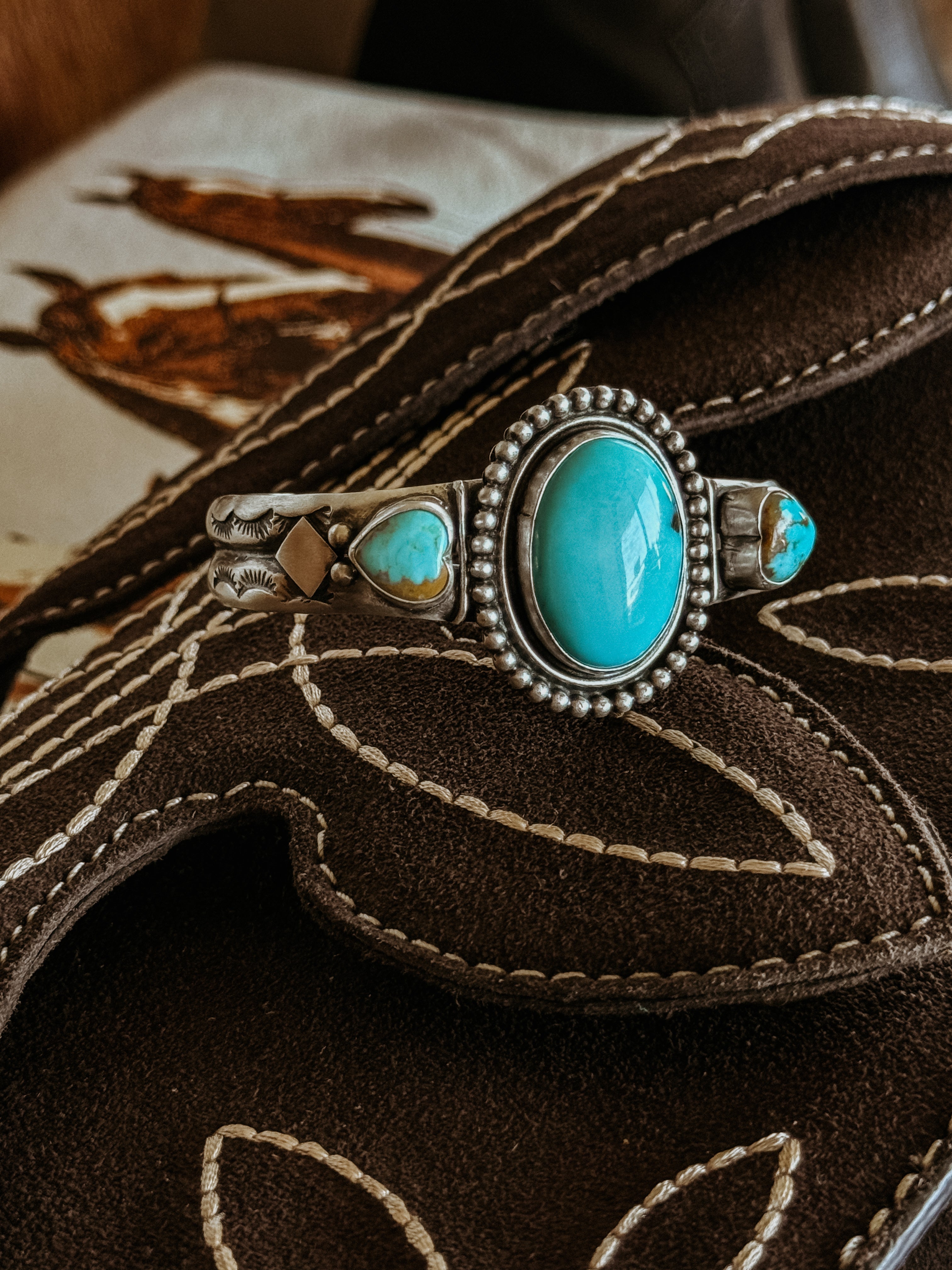Turquoise and silver western bracelet on embroidered brown suede boot, cowgirl jewelry