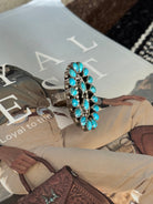 Oval turquoise statement ring with silver setting on western fashion magazine background