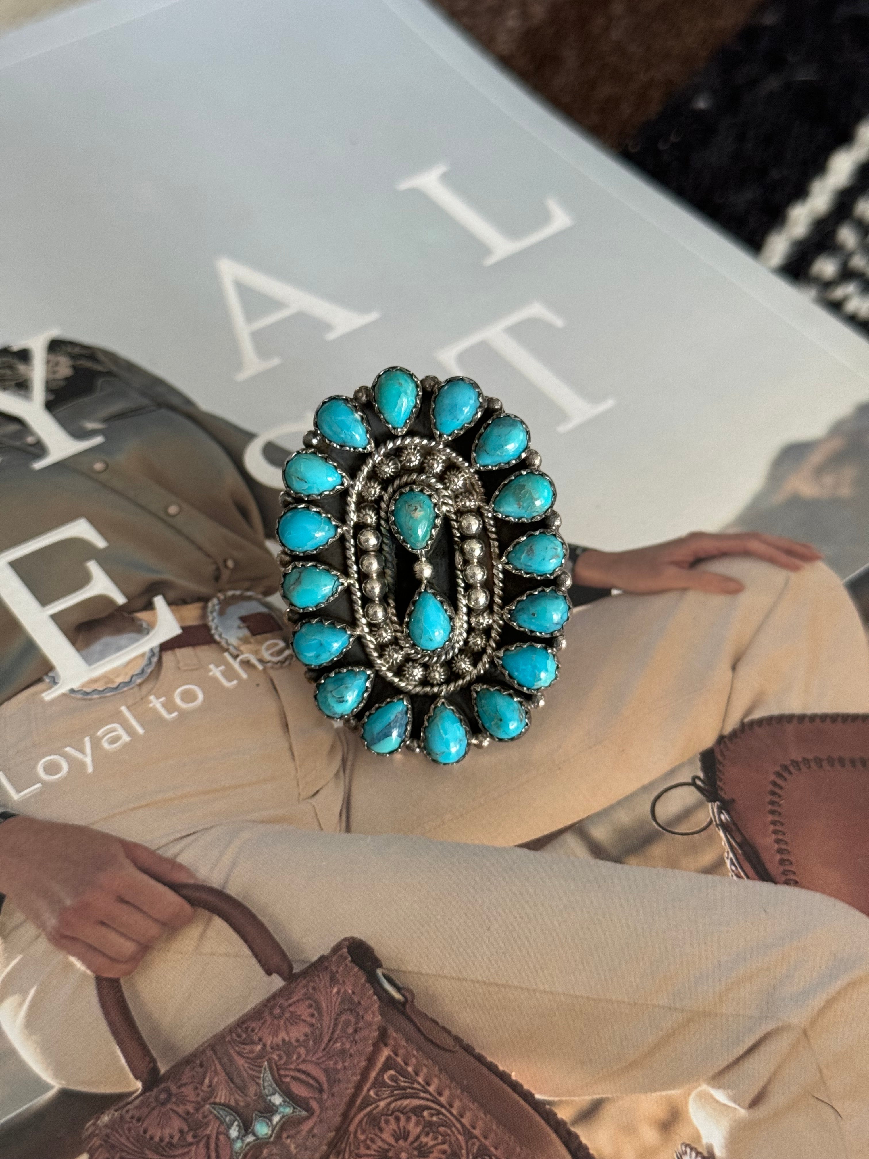 Western boho oval statement ring with turquoise stones on magazine background