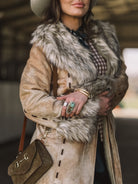 Woman in western fur-trimmed suede coat, turquoise ring, brown bag, cowgirl style