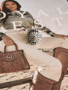 Thunderbird pendant chain necklace displayed on wooden slab with serape fabric underneath - The Wild J