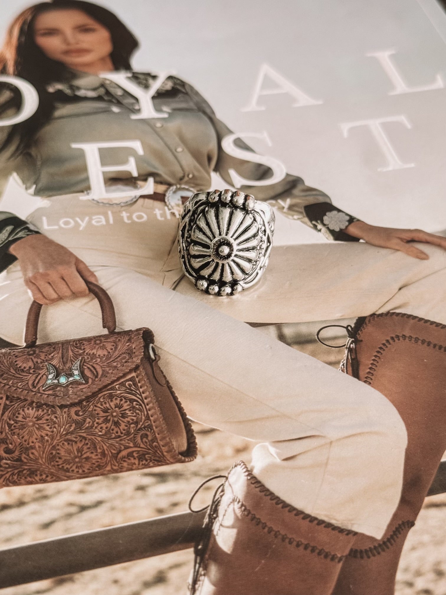 Thunderbird pendant chain necklace displayed on wooden slab with serape fabric underneath - The Wild J