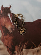 Western horse charm bracelet on rustic horse background, boho cowgirl jewelry style