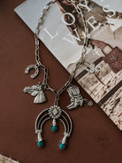 Thunderbird pendant chain necklace displayed on wooden slab with serape fabric underneath - The Wild J