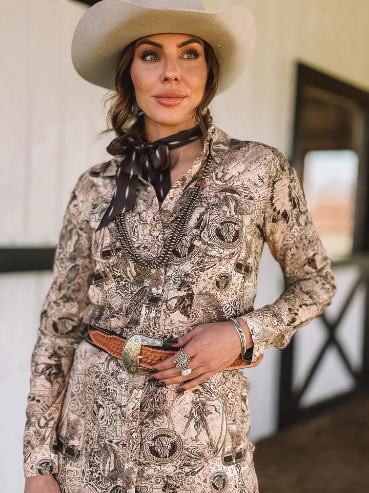 Woman in western cowboy hat, printed boho shirt, concho belt, and western jewelry outdoors