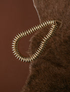 Thunderbird pendant chain necklace displayed on wooden slab with serape fabric underneath - The Wild J