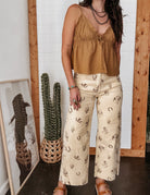 Thunderbird pendant chain necklace displayed on wooden slab with serape fabric underneath - The Wild J