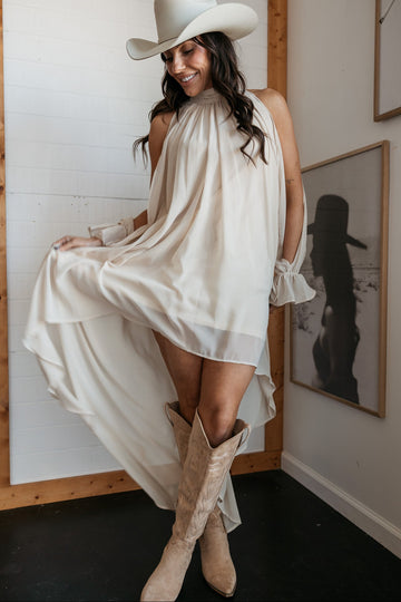 flowing white dress and cowboy hat with tan cowboy boots