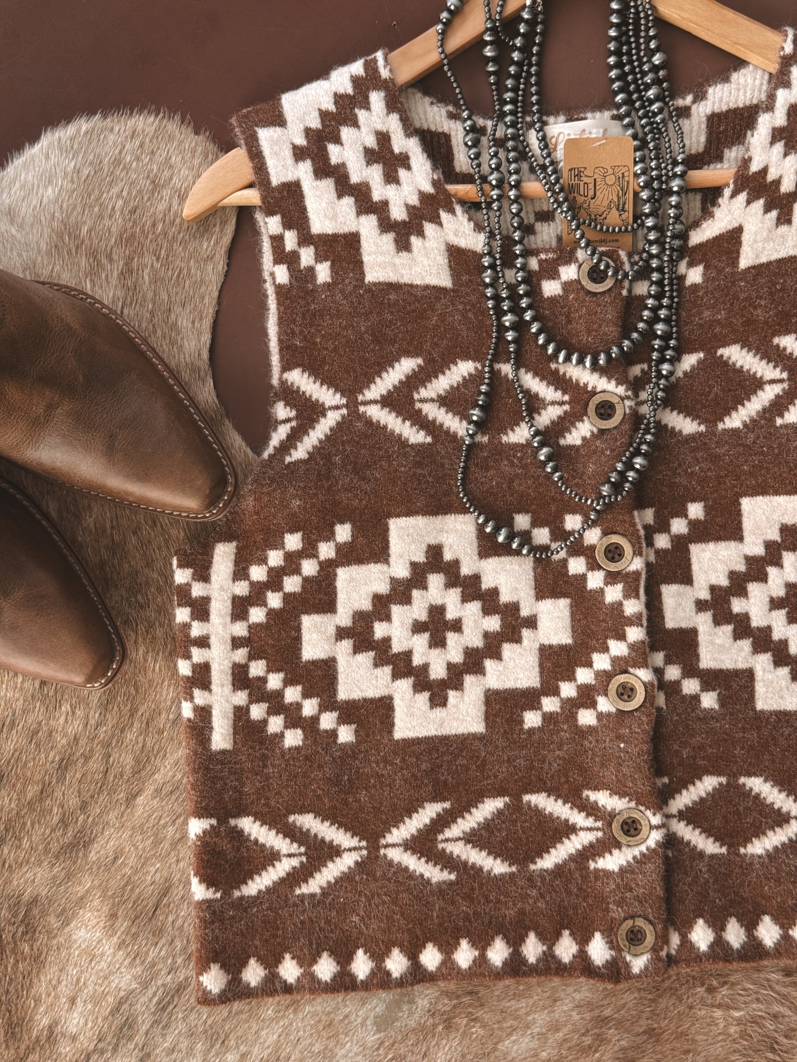 Western boho brown and white Aztec knit vest with silver beaded necklace and cowboy boots