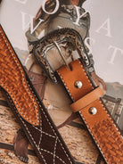Tooled leather western belts with ornate silver buckles on cowgirl fashion magazine