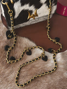 Thunderbird pendant chain necklace displayed on wooden slab with serape fabric underneath - The Wild J