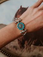 Thunderbird pendant chain necklace displayed on wooden slab with serape fabric underneath - The Wild J