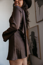 Woman in brown satin western mini dress and black hat, boho outfit indoors